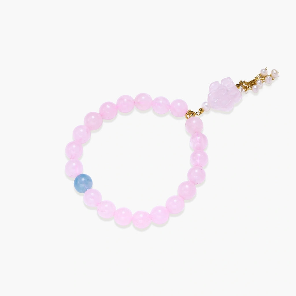 Stretchy beaded bracelet with pink rose quartz, blue aquamarine, carved floral pendant, and pearl tassel clasp.